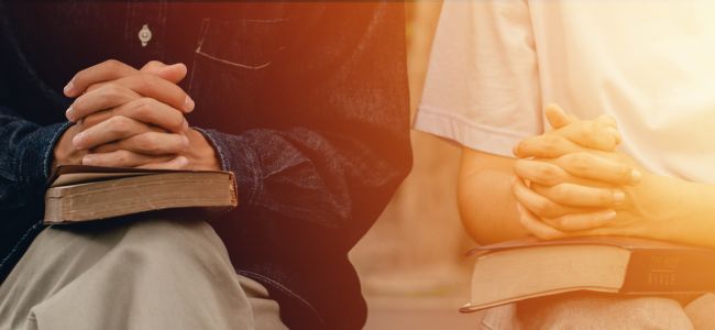 2 women praying with Bible